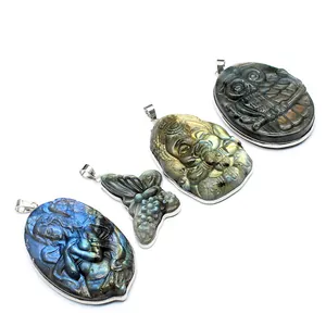 Detailed view of four carved natural labradorite pendants: mermaid, butterfly, owl, ganesha.