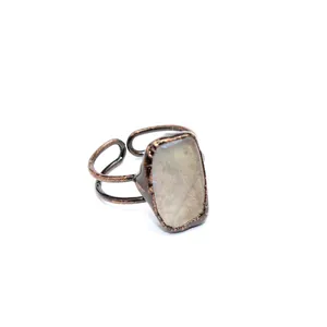 Vista dettagliata di un anello in rame vintage con pietra naturale grezza quadrata.