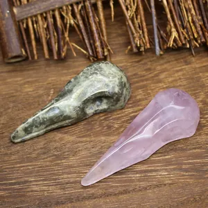Macro detail of hand-carved natural rose quartz and green stone raven skull ornaments
