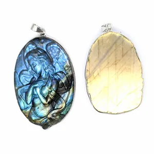 Detail view of iridescent labradorite mermaid pendant with intricate carving on white background