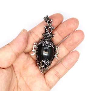 Antique silver bottle-shaped egg crystal pendulum pendant held in hand for scale