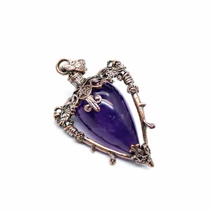 Macro view of the intricate bronze metalwork on a purple crystal stone pendant