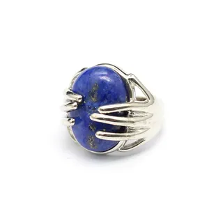 Silver adjustable ring with a unique hand-shaped clasp holding an oval blue lapis lazuli stone.