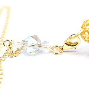 Detailed view of the lobster clasp and iridescent faceted crystal beads on a gold chain