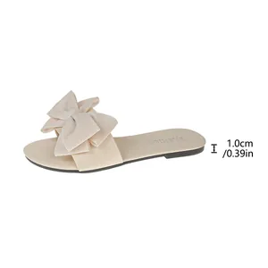 Dettaglio sandalo piatto beige con grande fiocco e suola spessa 1,0 cm