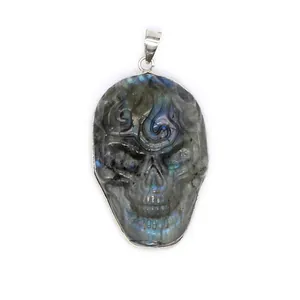 Close-up of hand-carved natural labradorite skull pendant showing blue labradorescence
