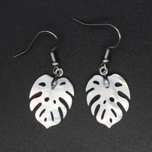 Vista detallada de pendientes de hoja de Monstera en nácar blanco con brillo perla.