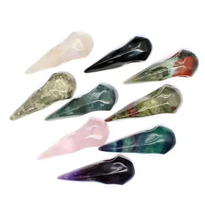 Detailed macro view of various hand-carved natural crystal raven skull charms for decoration.