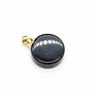 Gros plan d'un pendentif flacon de parfum en pierre naturelle ronde minimaliste.