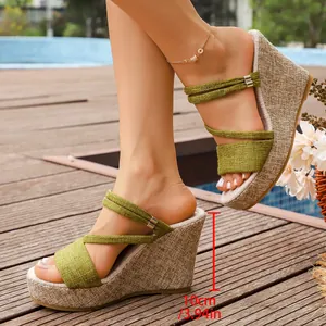 Détail de sandales compensées vertes avec mesure de la hauteur du talon de 10 cm.