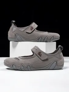 Detailed side view of grey Mary Jane style sports shoes with adjustable velcro strap