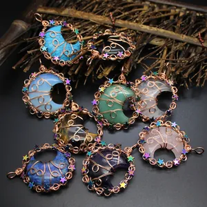 Close-up of handmade crescent moon crystal pendants with star wire wrapping