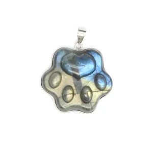 Close-up of a natural labradorite pendant carved into a detailed animal paw shape