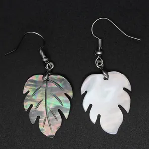 Primer plano de pendientes de hoja de monstera en abulón iridiscente y nácar blanco