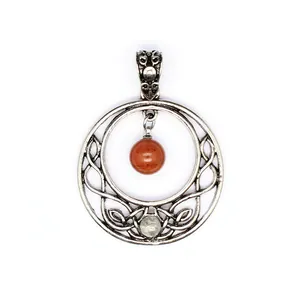 Detail view of a vintage silver Celtic knot pendant with natural red and clear stones