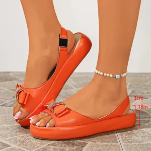 Detail of stylish orange platform sandals with a 3cm low heel and buckle accent