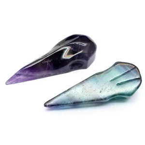 Detailed macro view of carved amethyst and fluorite crystal bird skulls for home decor.