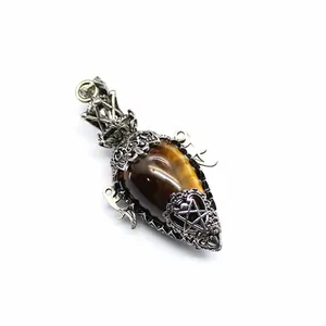Close-up of antique silver filigree pendant with tiger eye stone and pentagram