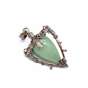 Close-up of a vintage bronze heart-shaped pendant featuring a green natural stone inlay