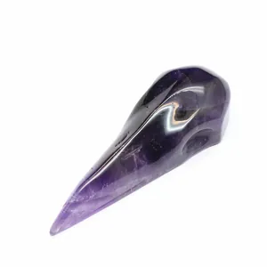 Detailed view of a hand-carved and polished amethyst crystal raven bird skull ornament