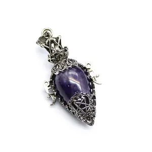 Detailed macro view of an antique silver egg-shaped amethyst pendulum pendant with pentagram