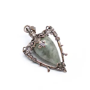 Detailed macro view of vintage bronze-tone bottle pendant with natural grey teardrop stone