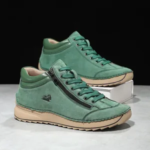 Detail shot of green suede casual shoes with side zipper and hand-stitched seams.