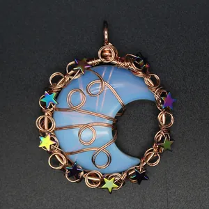 Detailed view of a handmade wire-wrapped moon pendant with colorful metallic stars