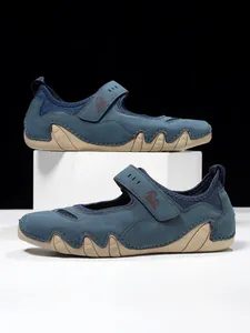 Detailed close-up view of blue Mary Jane casual shoes with wavy tan rubber soles and Velcro