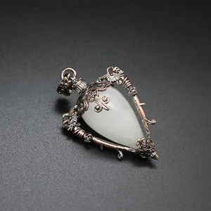 Detailed macro view of a vintage bronze heart pendant with translucent white stone.