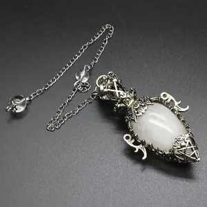 Macro view of antique silver filigree pendulum with egg-shaped white moonstone