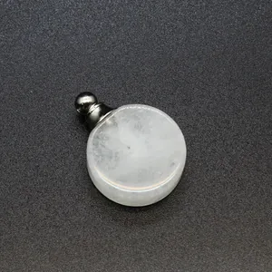 Vue détaillée d'un pendentif flacon de parfum en pierre naturelle blanche et métal.