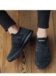 Breathable black knit running shoes for men and women shown on a natural wooden floor