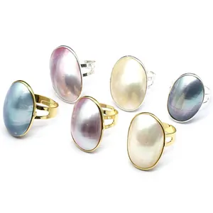 Minimalist adjustable Mabe pearl rings with iridescent oval shells in multiple colors.