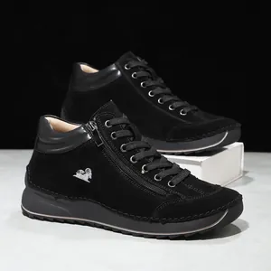 Detailed view of black suede casual boots with hand-stitched seams and side zipper.