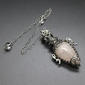 Macro view of an antique silver cage pendulum pendant with a rose quartz crystal