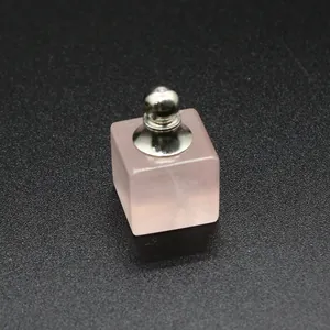 Gros plan détaillé d'un pendentif flacon d'huile essentielle en quartz rose carré.