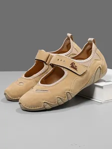 Detailed view of tan suede Mary Jane shoes with adjustable velcro strap and ram logo