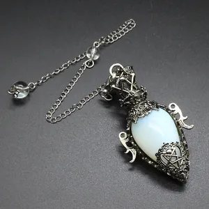 Detailed view of antique silver egg-shaped crystal pendulum pendant with ornate metalwork