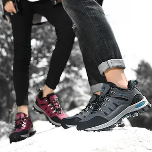 Two hikers wearing warm waterproof low-top mountaineering shoes on a snowy mountain trail