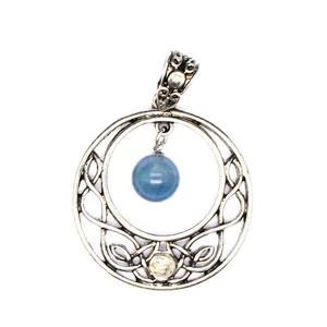 Close-up detail of vintage round stone pendant with intricate celtic knotwork and blue bead