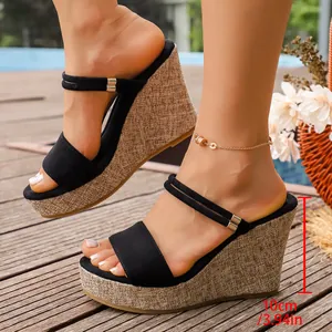 Détail de sandales compensées noires avec un talon de 10 cm et une plateforme texturée