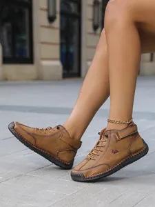 Λεπτομερής προβολή χειροποίητων καφέ casual επίπεδων μποτών για το φθινόπωρο και το χειμώνα