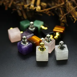 Détail de mini pendentifs flacons de parfum en cubes de pierre naturelle avec bouchons