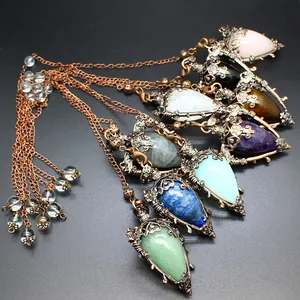 Detail view of vintage natural stone perfume bottle pendants with bronze filigree.