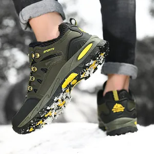Detailed side view of durable olive green hiking shoes with yellow accents on snow