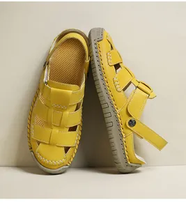 Detailed macro view of stylish yellow hollow-out summer sandals for women with thick soles