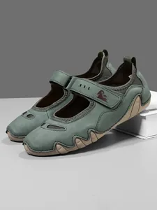 Close-up of green Mary Jane sport shoes with a velcro strap and wavy rubber sole.