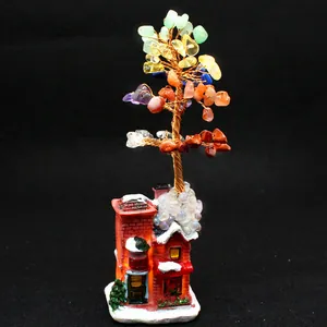 Detailed macro view of a handmade 7 chakra crystal money tree on a snowy red house base.