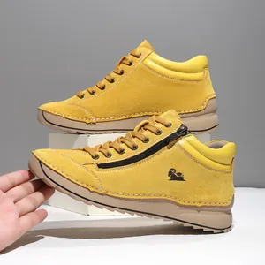 Detail view of yellow suede casual shoe with side zipper and manual stitching